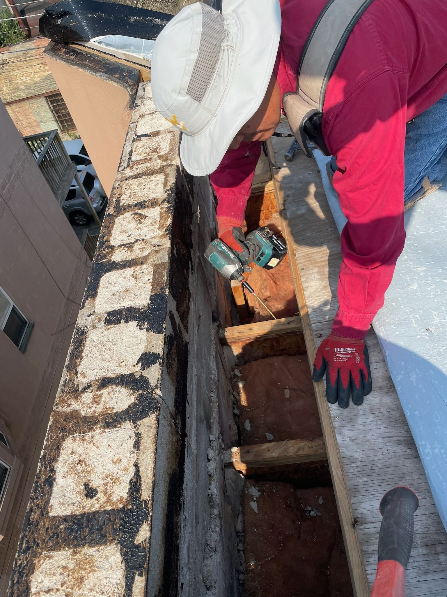 Worker drilling nails into trusses