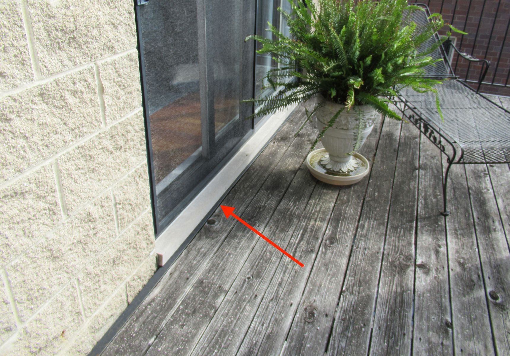 Sliding glass door onto rooftop deck, unflashed limestone sill, Rogers Park, Chicago