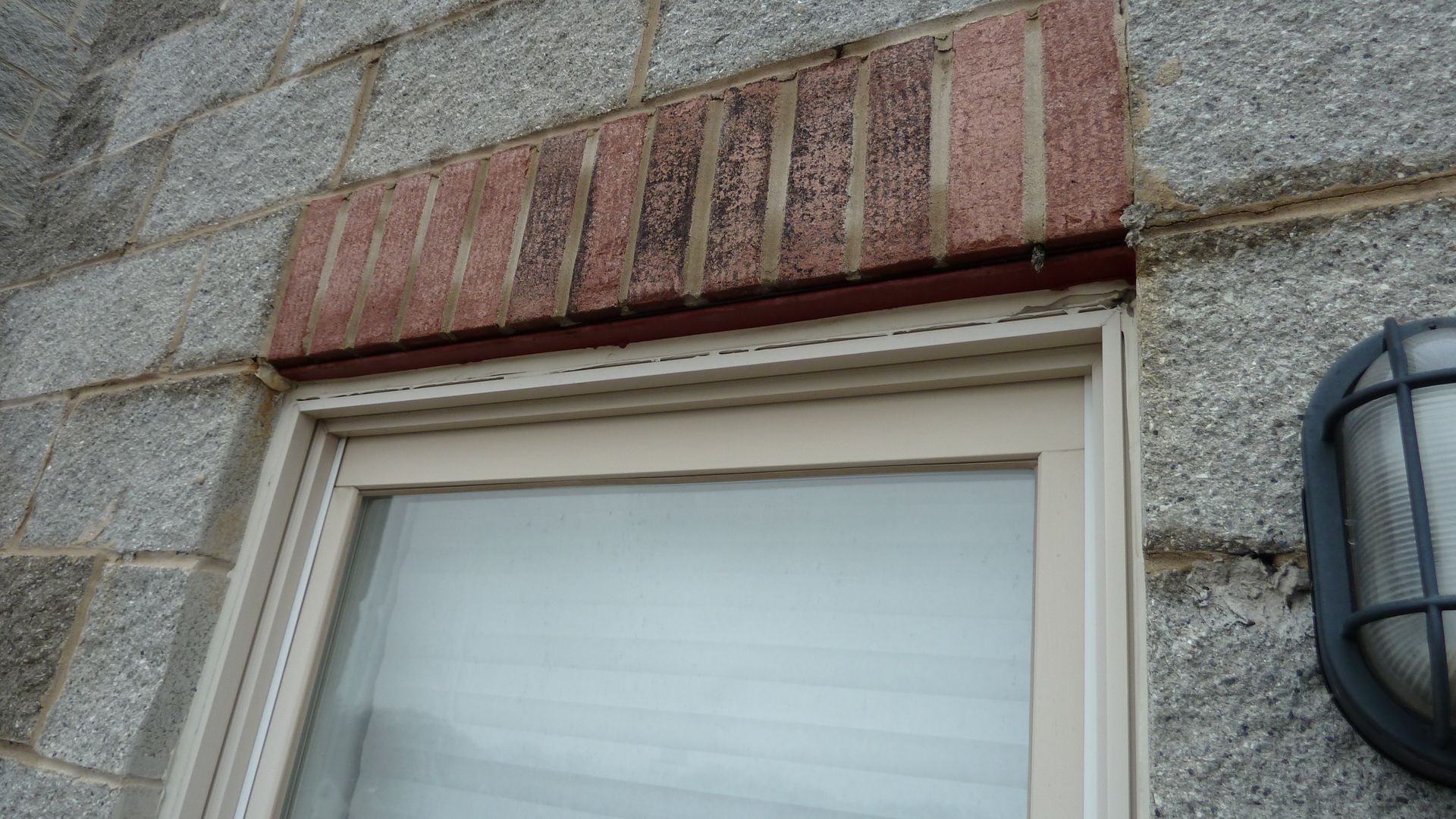 Brick window header in pattern called soldier leaking into window in Wrigleyville, Chicago