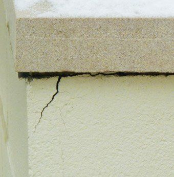 Cracked concrete block on parapet possibly caused by water in block freezing and thawing Chicago