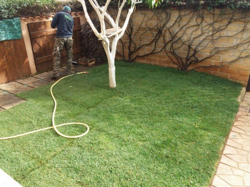 giardiniere mentre innaffia le piante