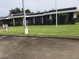 A blue and white building with a handicapped parking spot in front of it