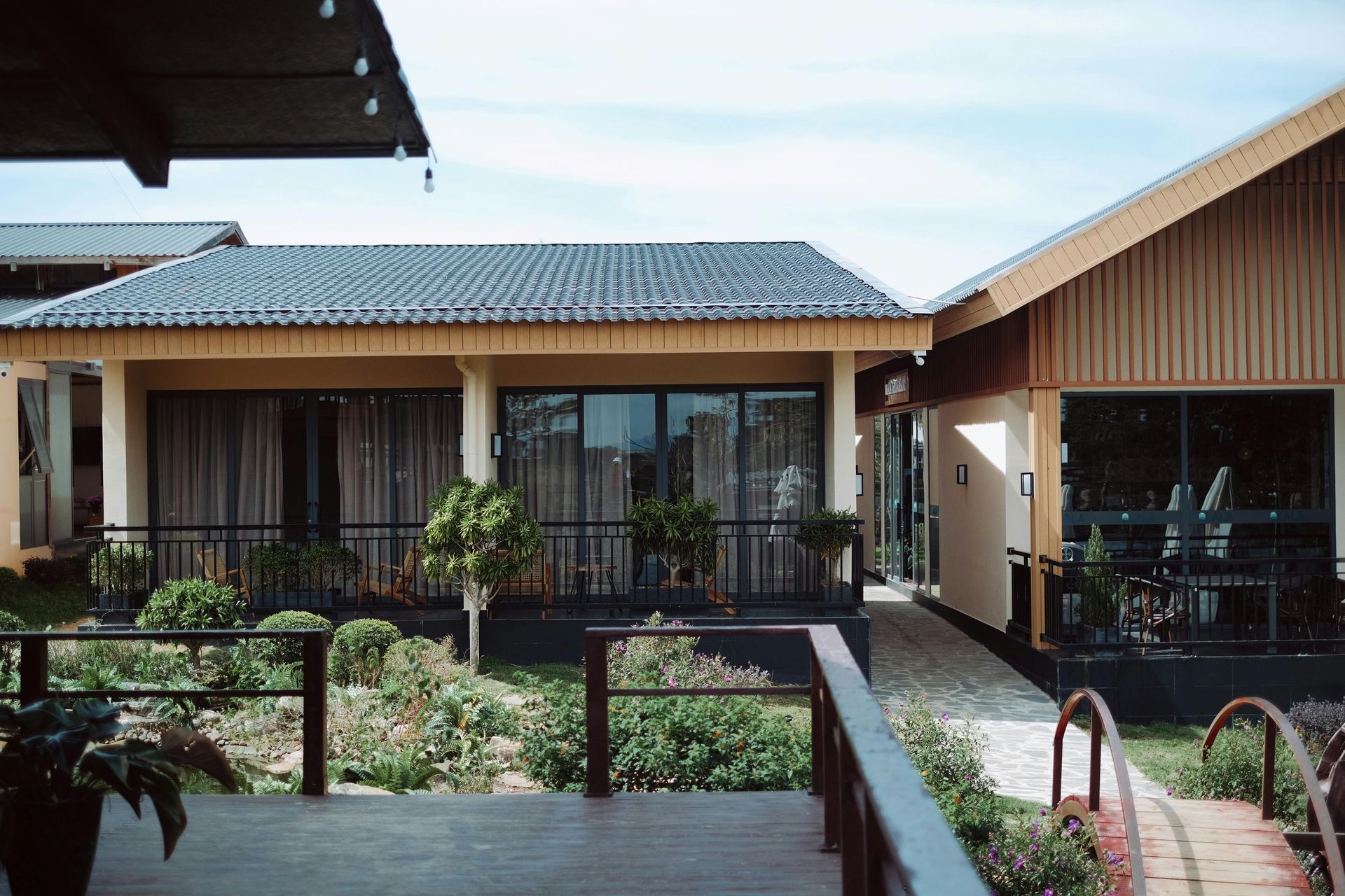 Buildings with tiled roofs, porch and landscaped garden.