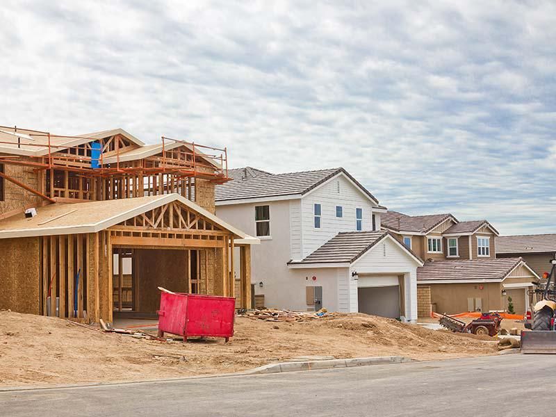 A row of houses are being built in a residential area.