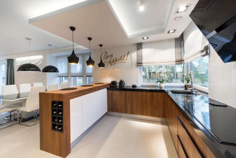 A modern kitchen with wooden cabinets and black counter tops