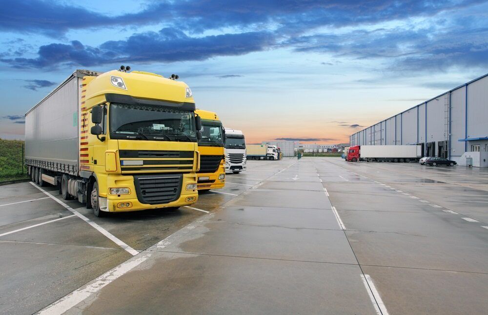 A Row Of Yellow Semi Trucks Are Parked — Newcastle Moving & Storage in Salt Ash, NSW