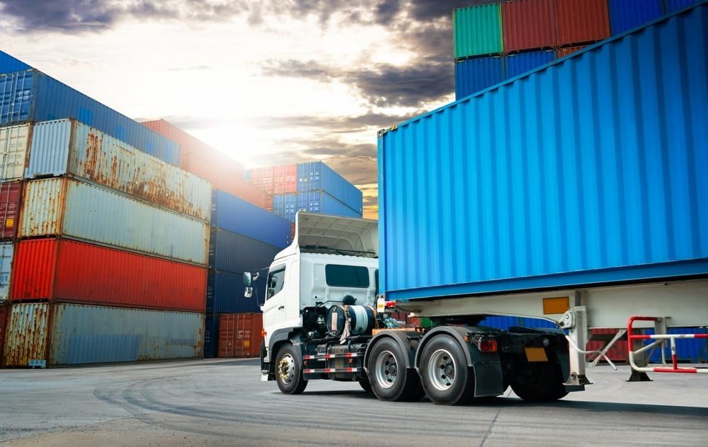 A Semi Truck Is Driving Through A Warehouse Filled With Containers — Newcastle Moving & Storage in Salt Ash, NSW