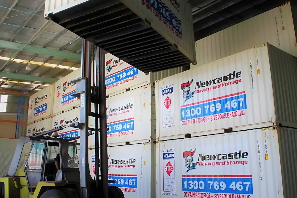 A Forklift Is Lifting A Shipping Container In A Warehouse — Newcastle Moving & Storage in Salt Ash, NSW