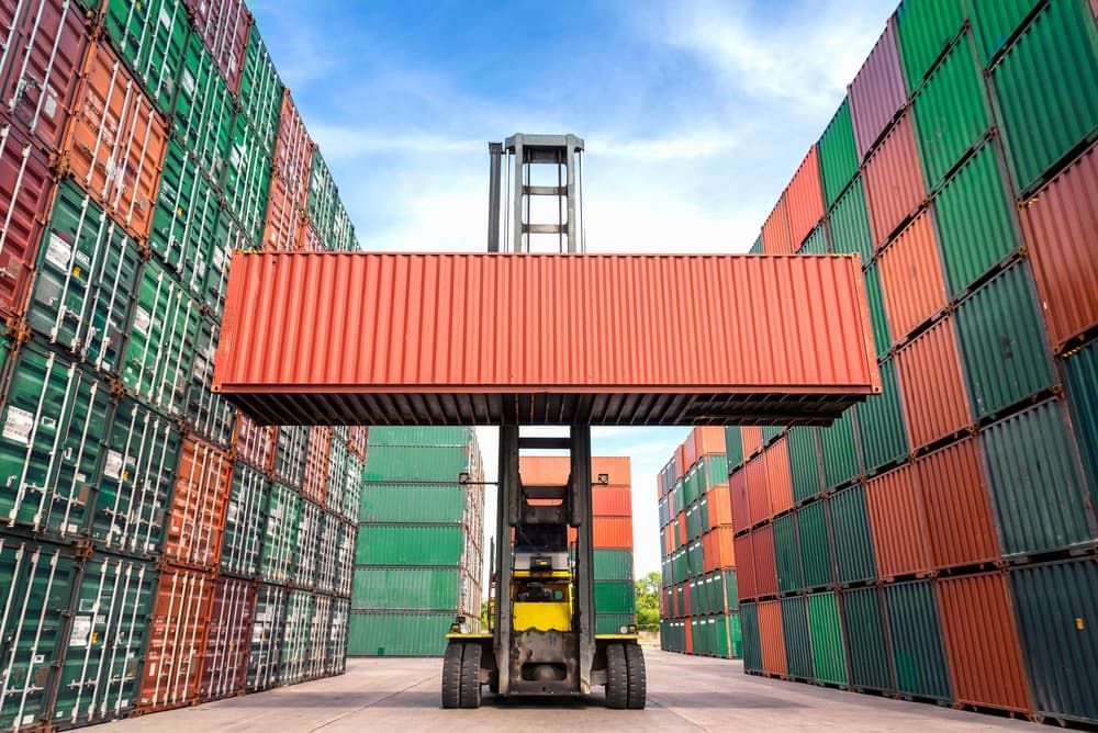 A Forklift Is Lifting A Container In A Warehouse Filled — Newcastle Moving & Storage in Salt Ash, NSW