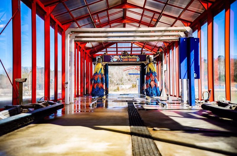 A car wash with a red roof and a lot of windows.