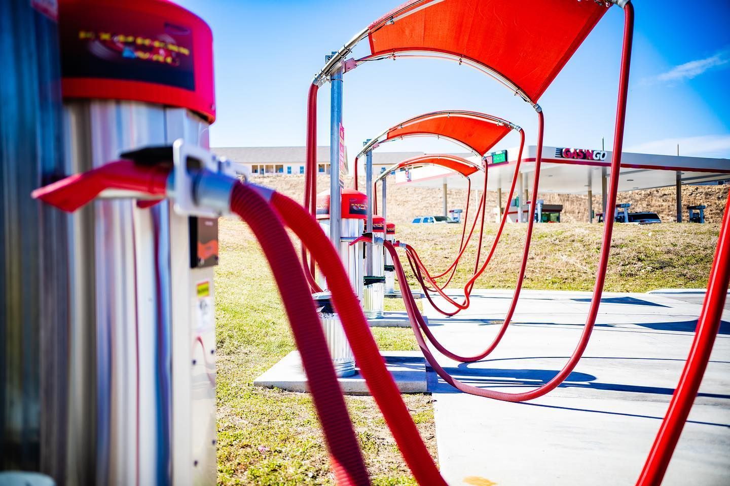 A row of red hose connected to a machine at a car wash