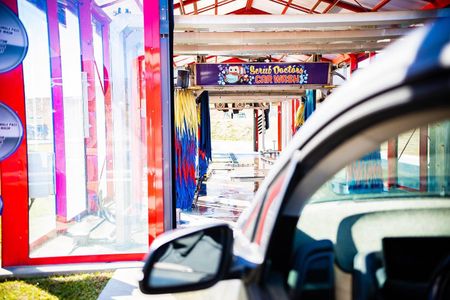 A car is parked in front of a car wash.