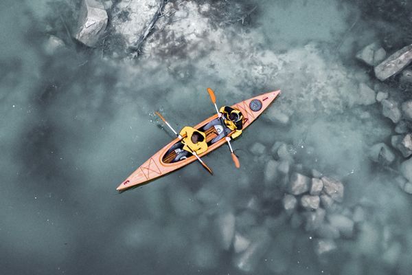 Zwei Personen in einem roten Boot auf einem Fluss