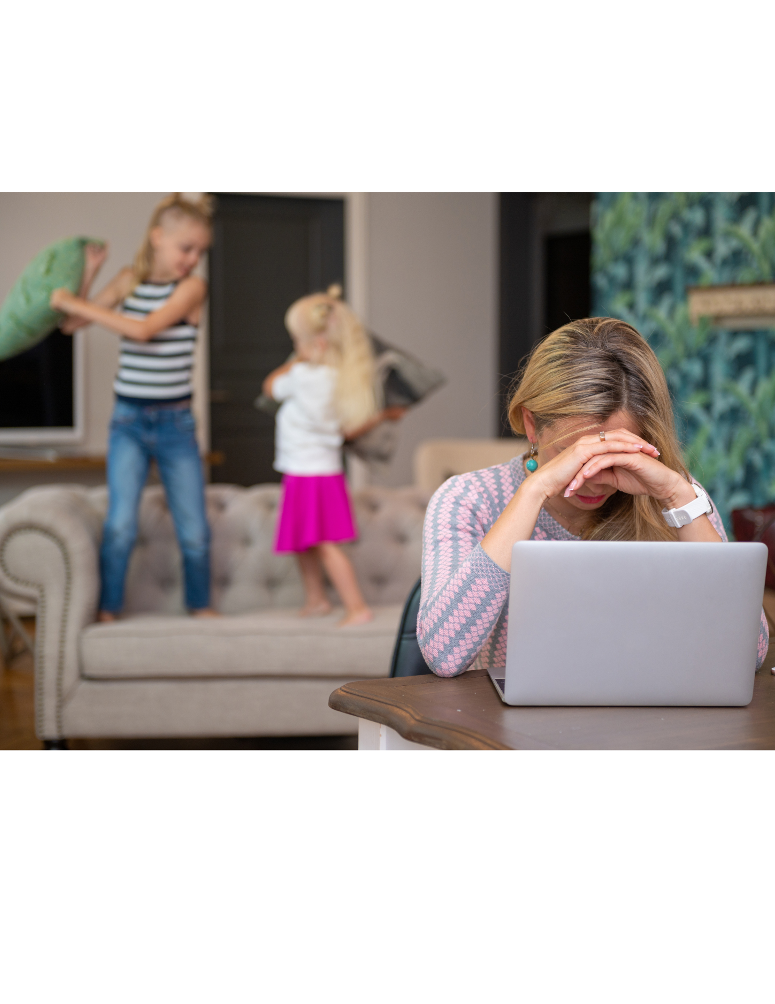 A woman is sitting at a table with a laptop in front of her.