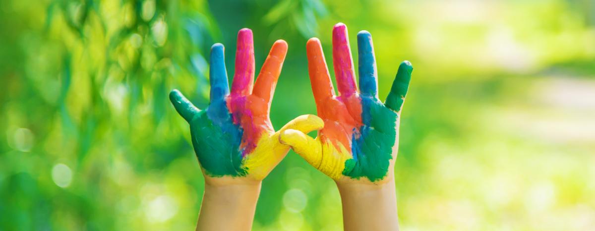 A child 's hands are painted in different colors.