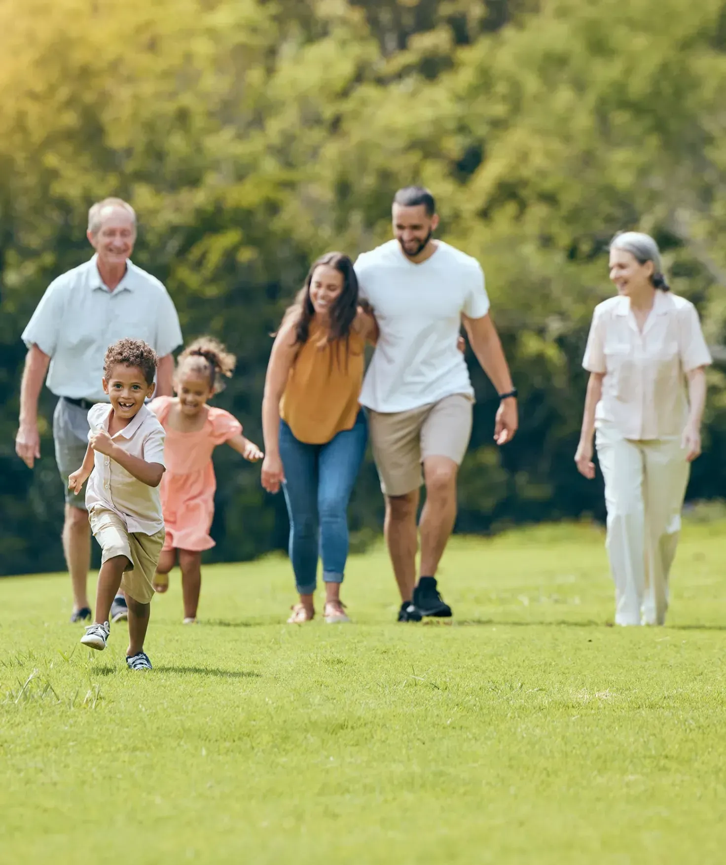 Bald man wearing a blue button-down shirt smiles at the camera. White backdrop.