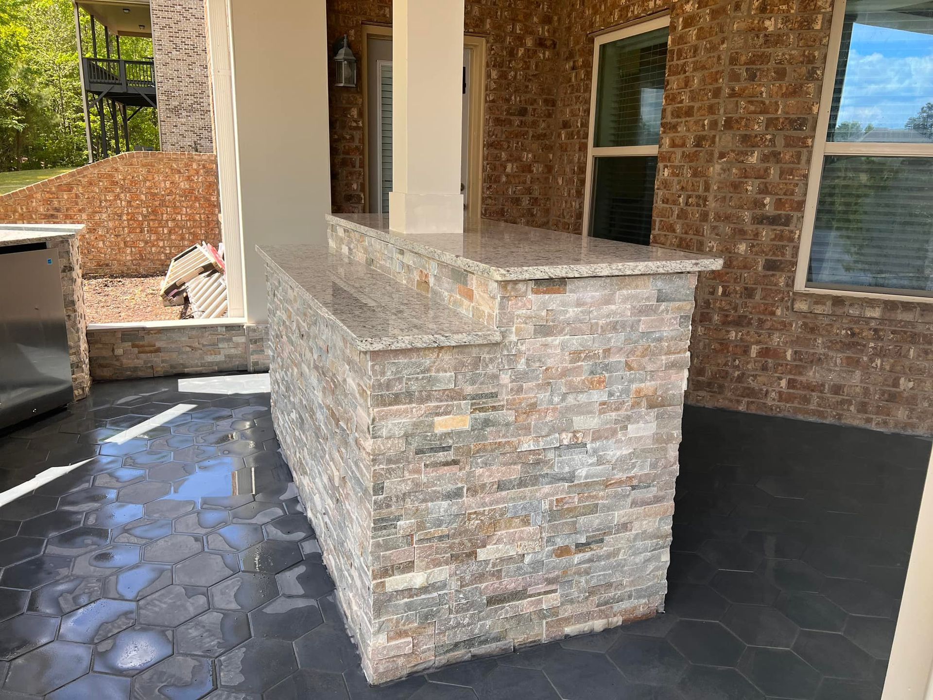 A brick building with a stone bar in front of it.