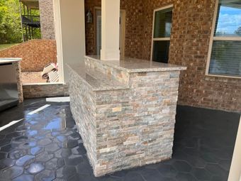 A brick building with a stone bar in front of it.