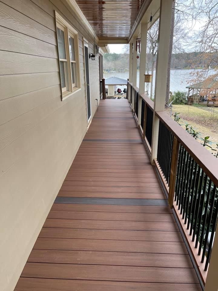 A long wooden walkway leading to a house with a lake in the background.
