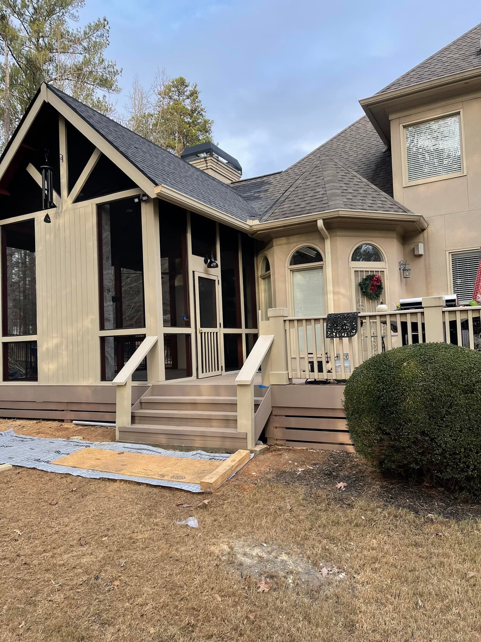 A large house with a screened in porch and stairs.
