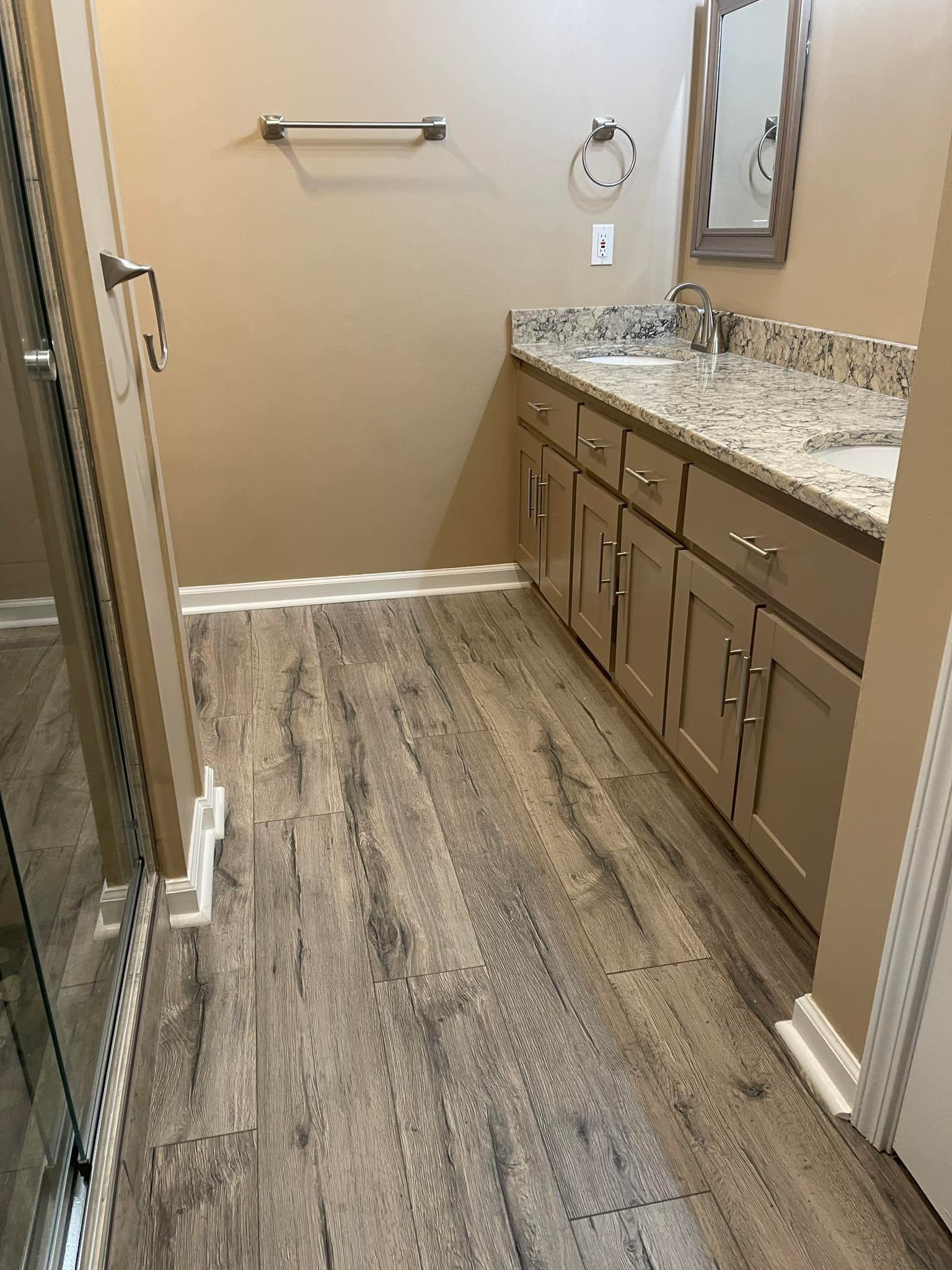 A bathroom with a sink , cabinets , and a mirror.