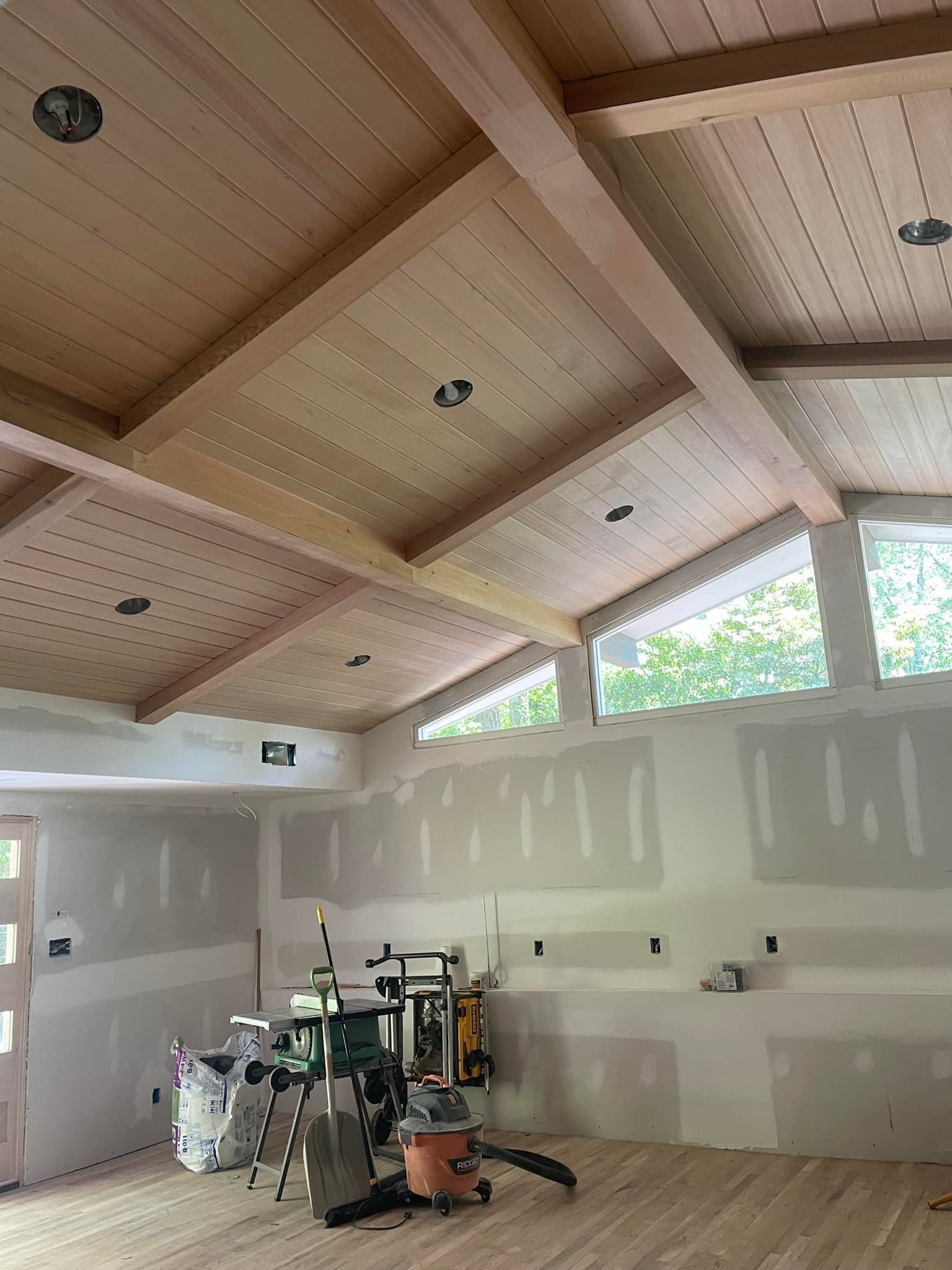 A room with a wooden ceiling and a lot of windows.