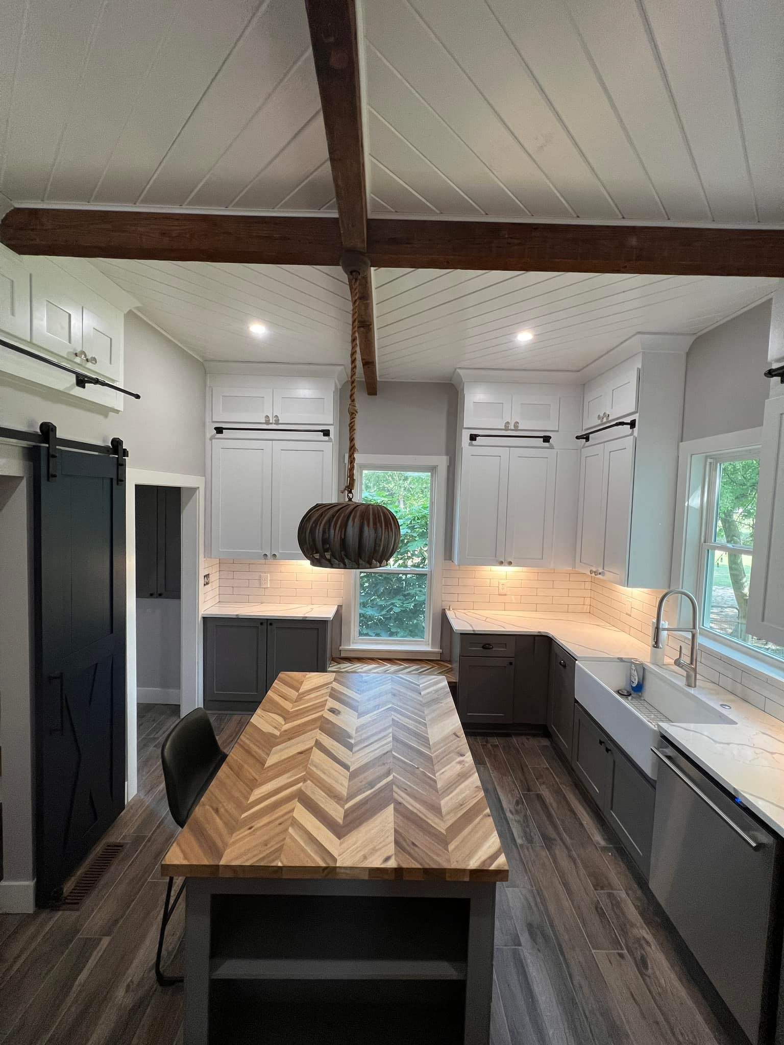 A kitchen with a long wooden table and a sliding barn door.