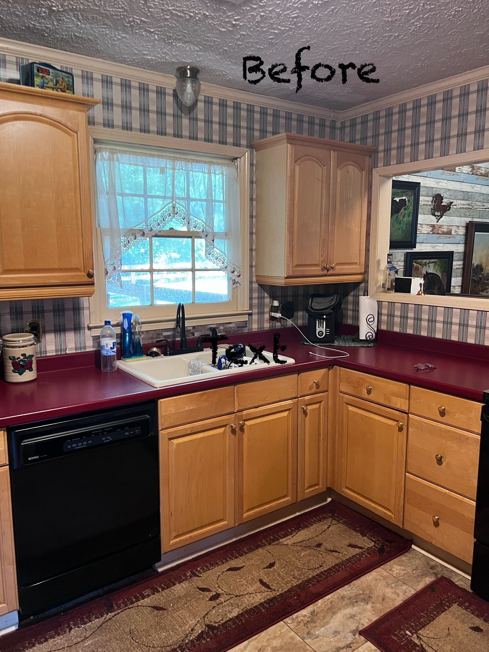 Kitchen with light wood cabinets, red countertops, black appliances, and patterned wallpaper.