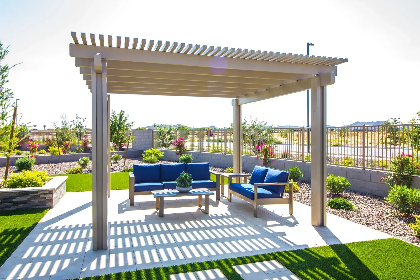 There is a pergola with a couch underneath it in the backyard.