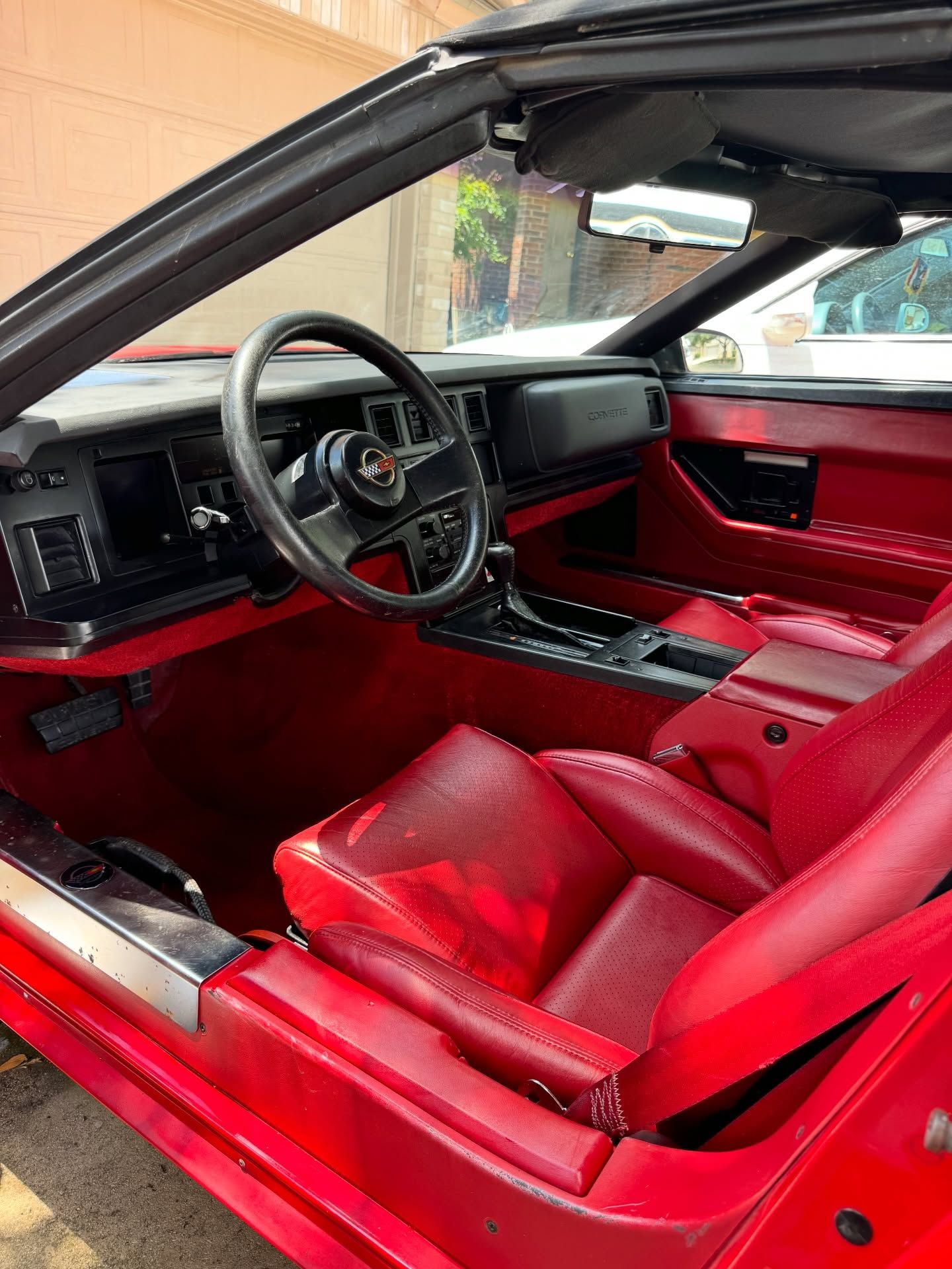 Red interior of a classic car, including seats, dashboard, and steering wheel.