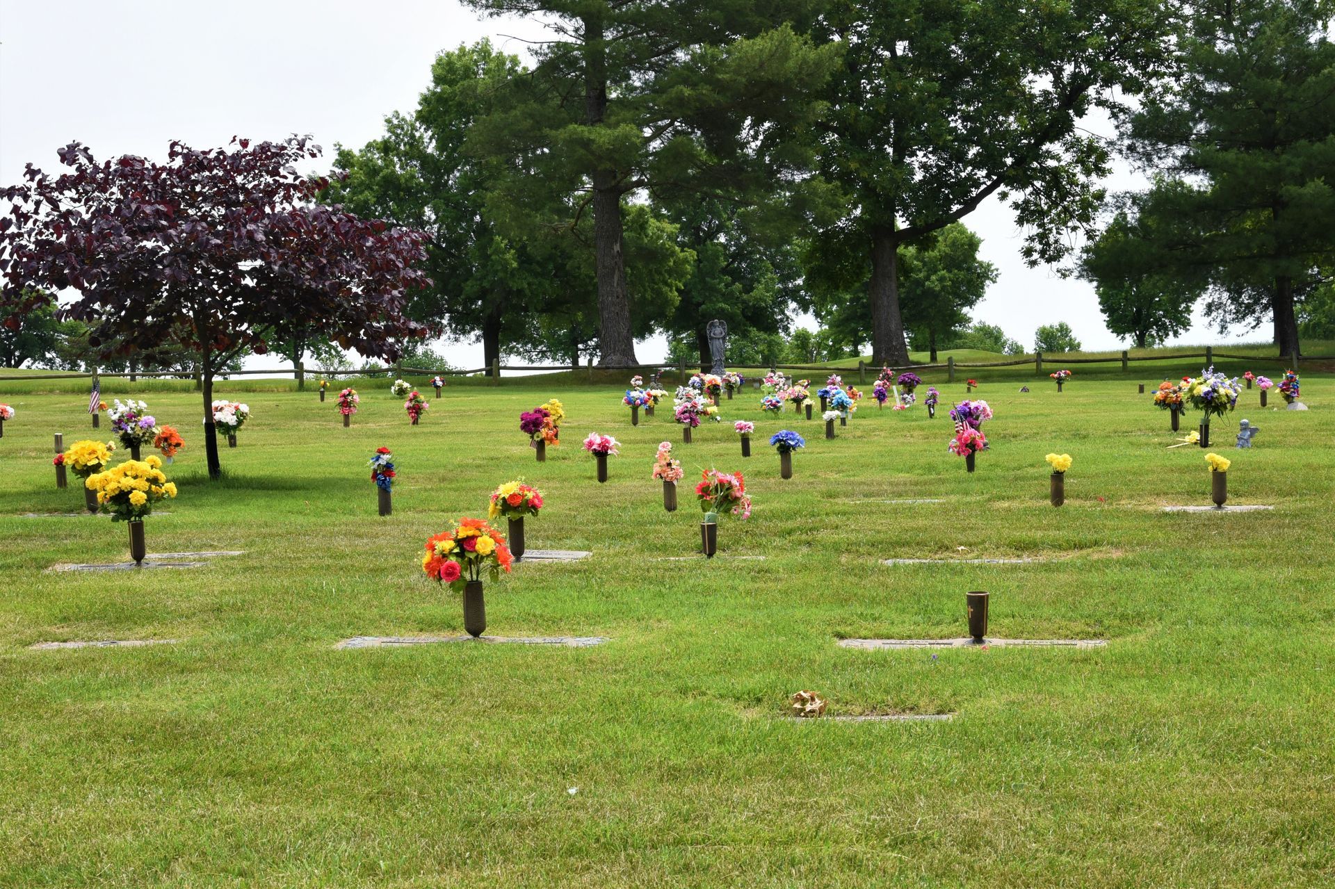 silk flowers next to flat grave markers in cemetery