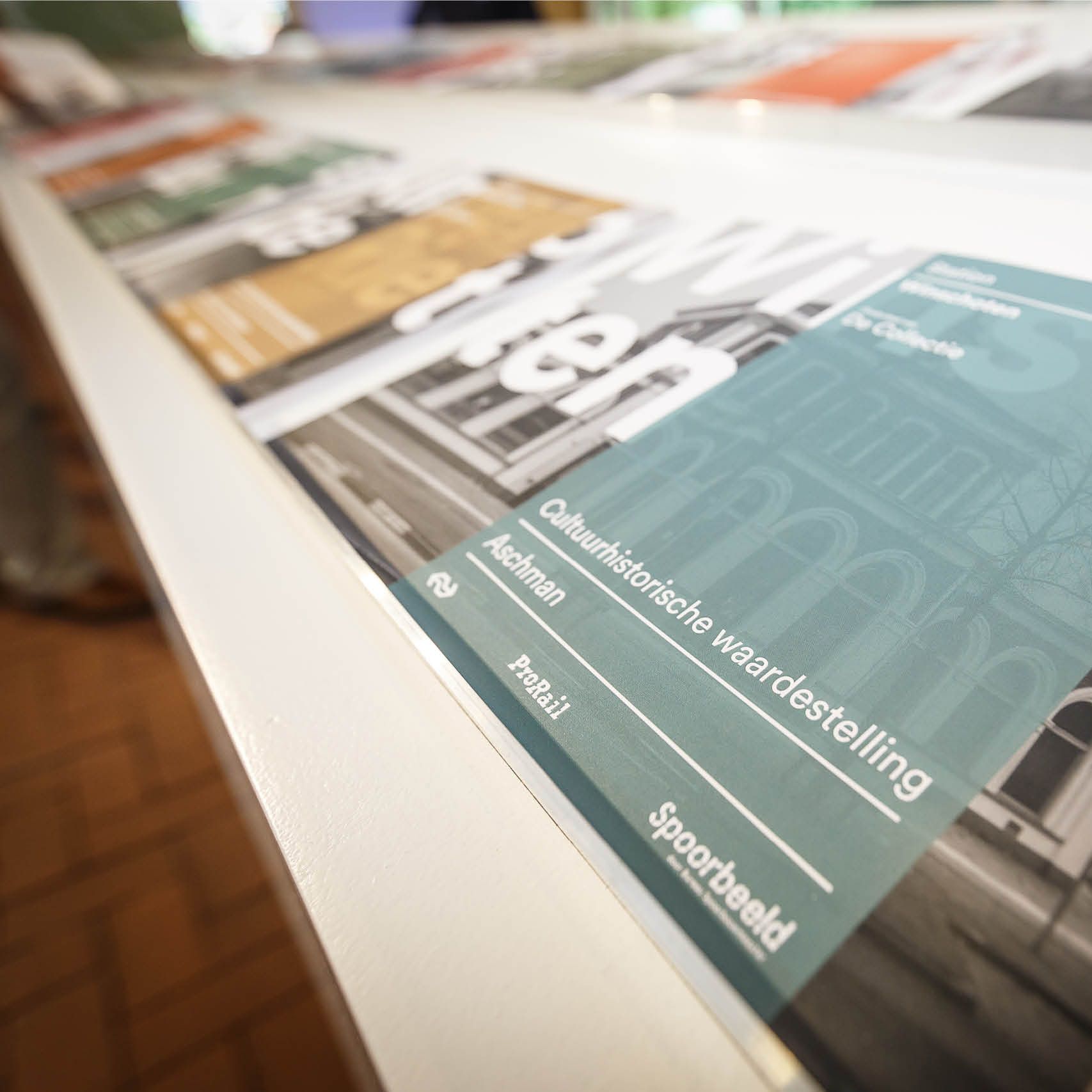 Magazines on a white shelf. One has green text: “Cultureel-historische waardestelling”.