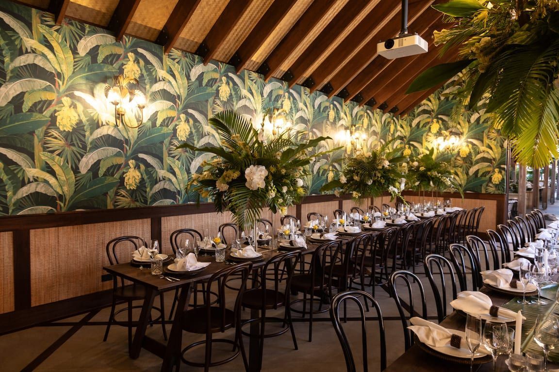 A restaurant with tables and chairs set up for a wedding reception.