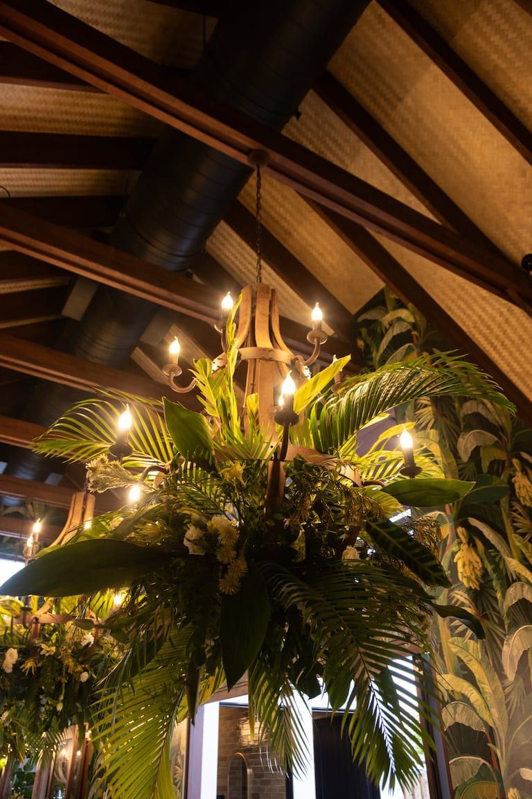 A chandelier hanging from the ceiling with flowers and candles.