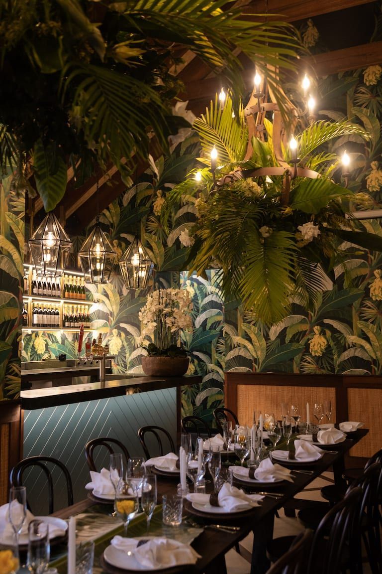 A restaurant with a lot of tables and chairs and a chandelier