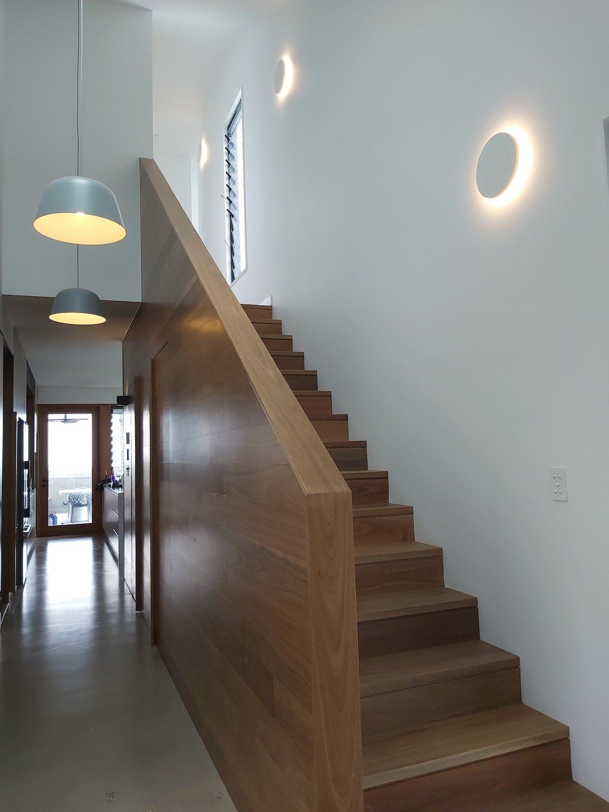 A hallway with stairs leading up to the second floor