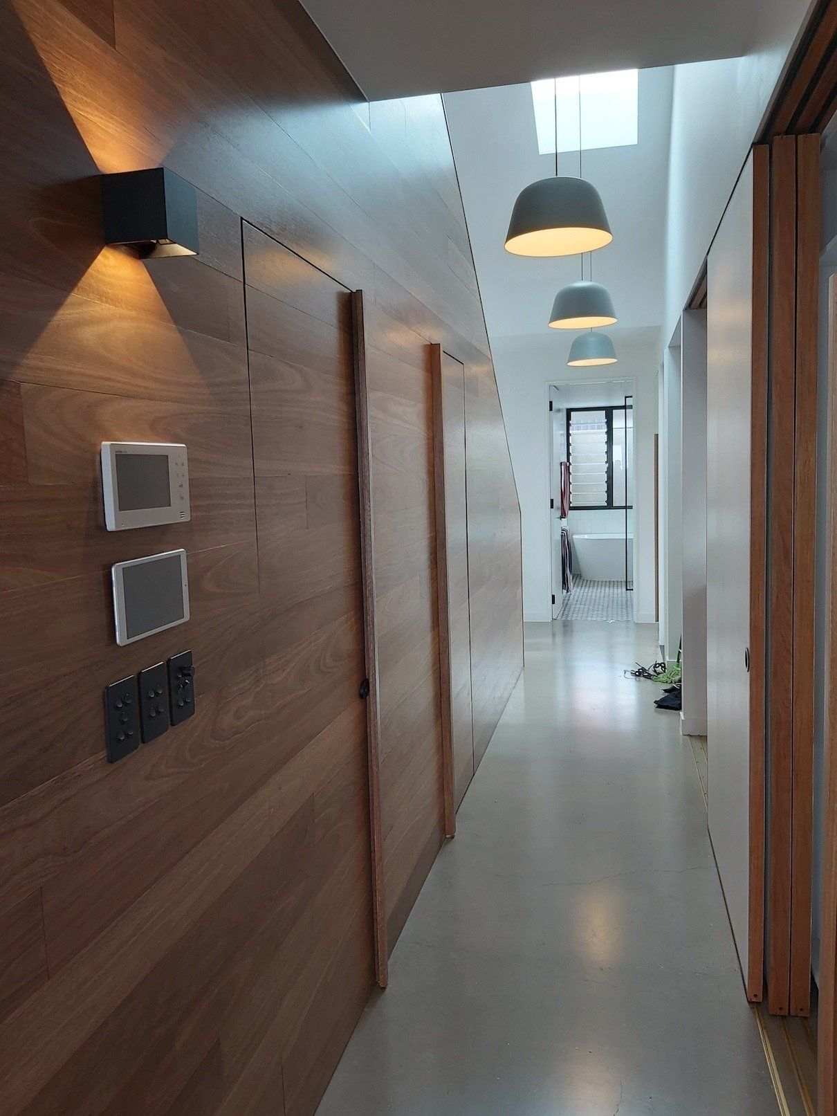 A long hallway with wooden walls and lamps hanging from the ceiling