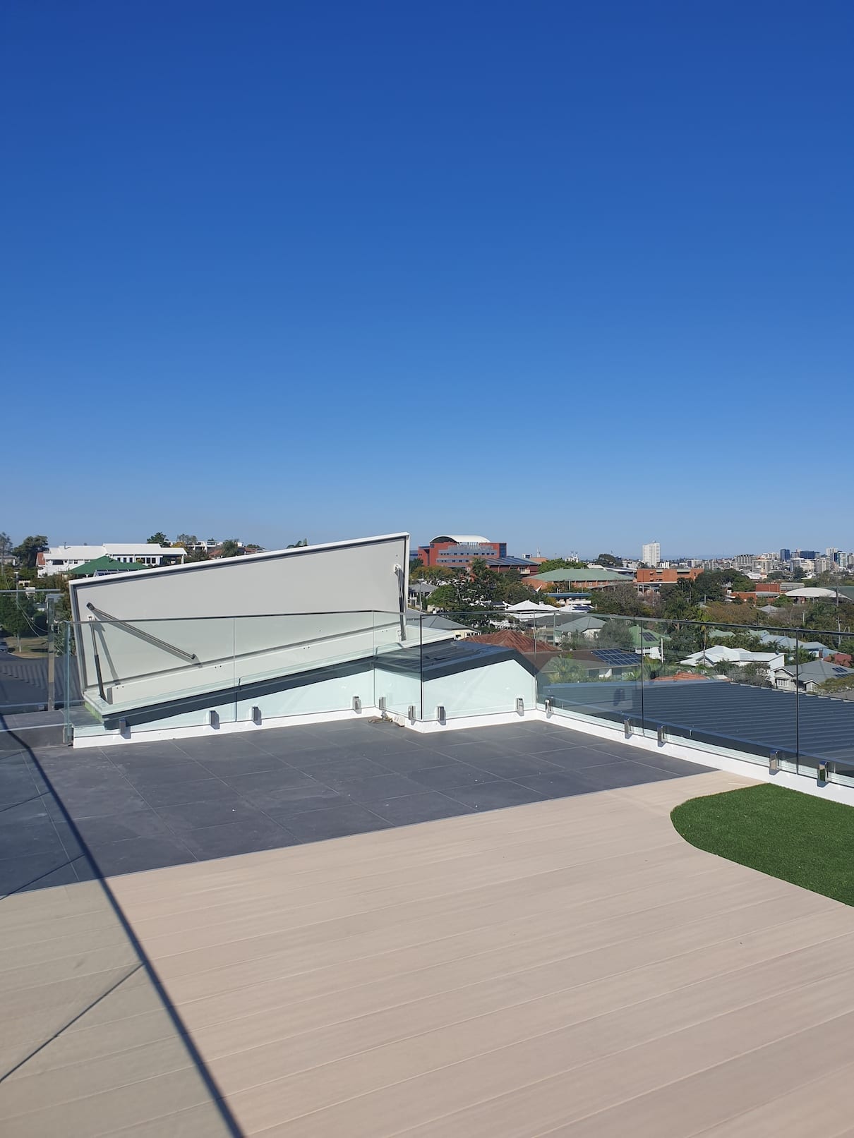 A balcony with a view of a city and a blue sky.