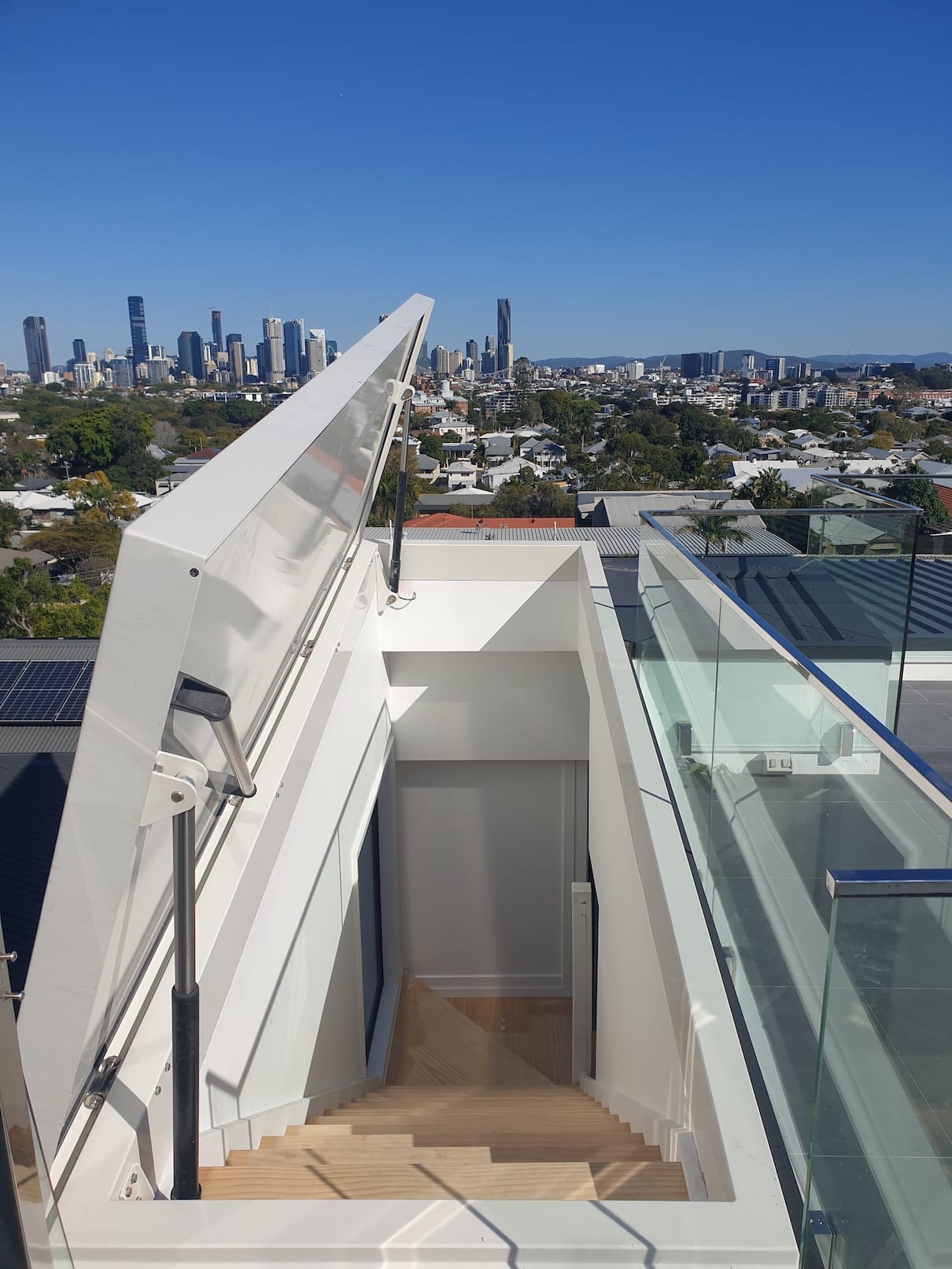 A staircase leading up to a rooftop with a city skyline in the background