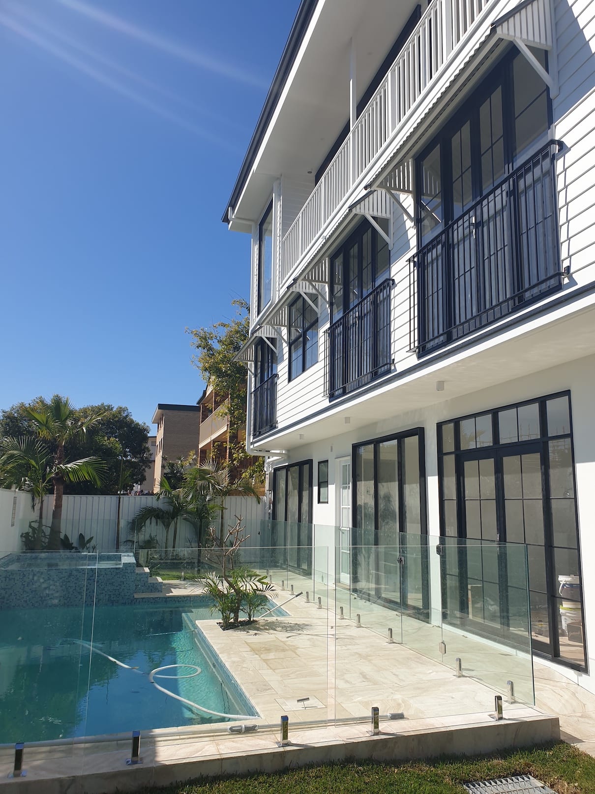 A large house with a swimming pool in front of it.
