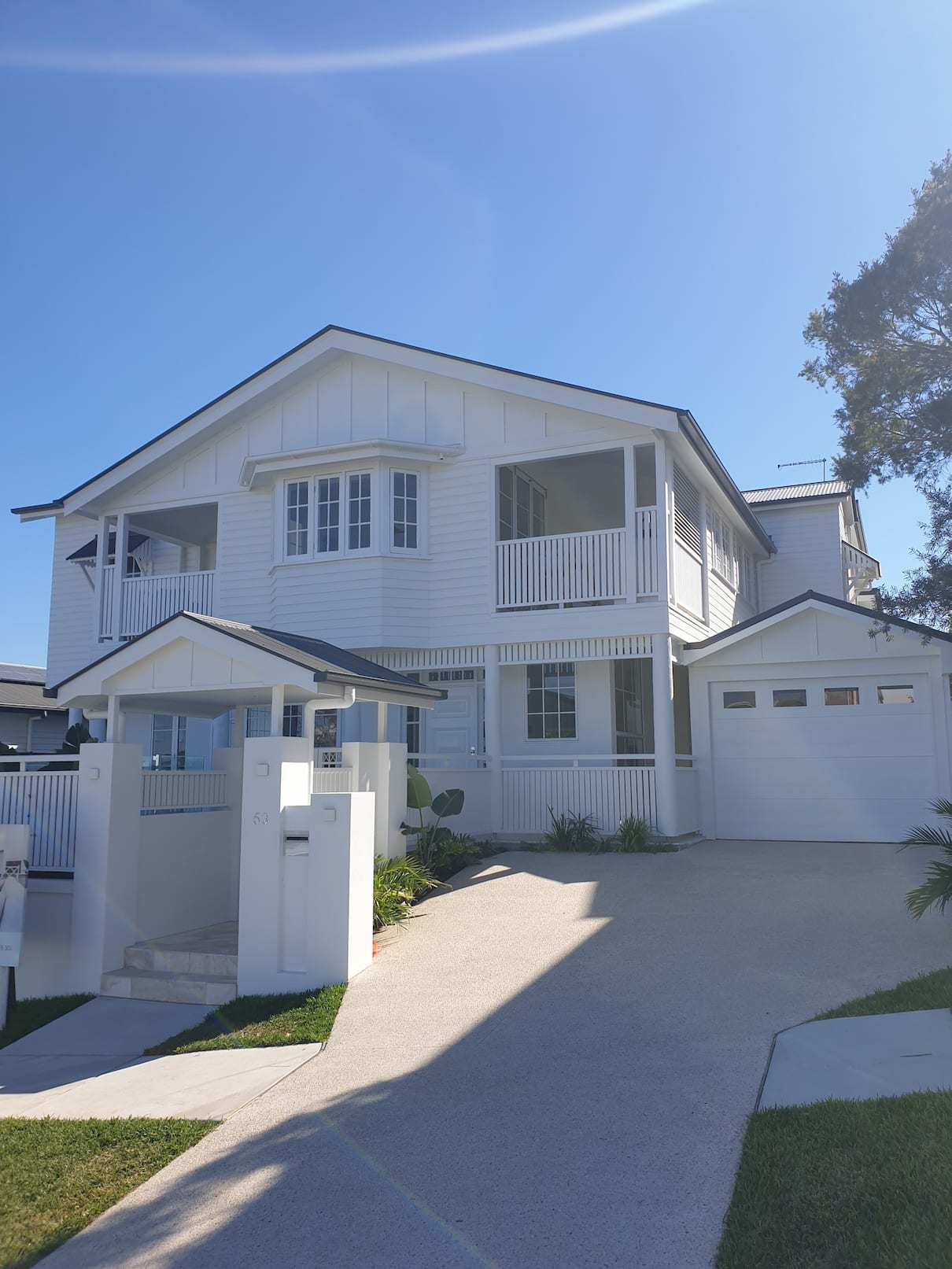 A large white house with a blue sky in the background