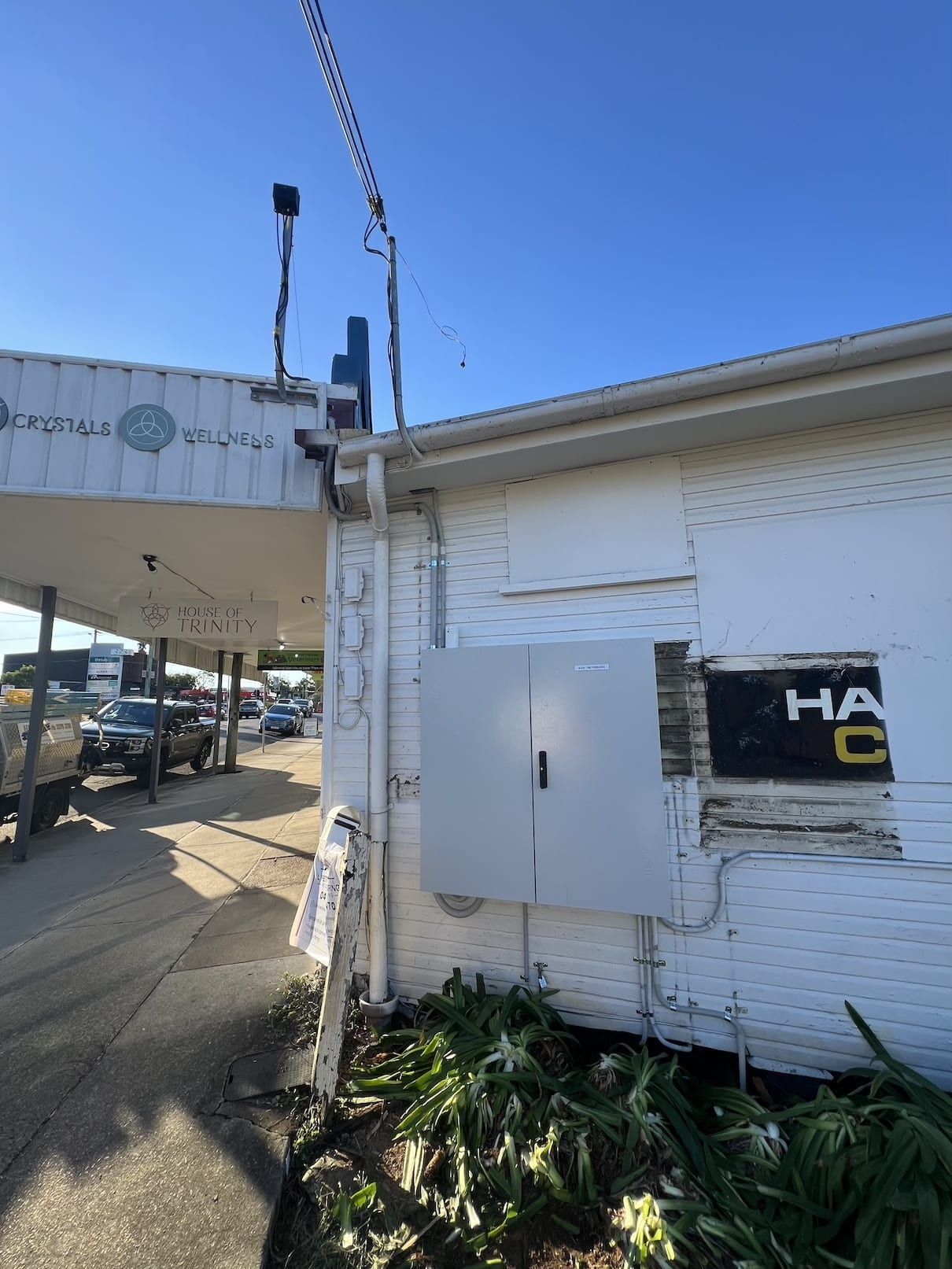 A white building with a black sign that says ha c on it