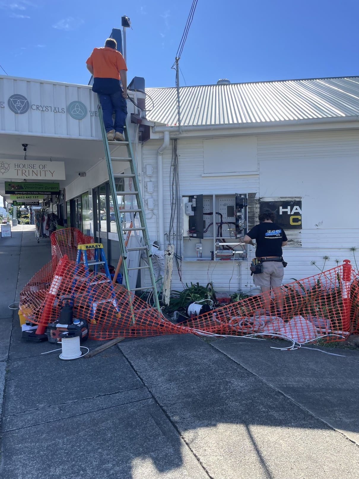 A man is standing on a ladder in front of a building.