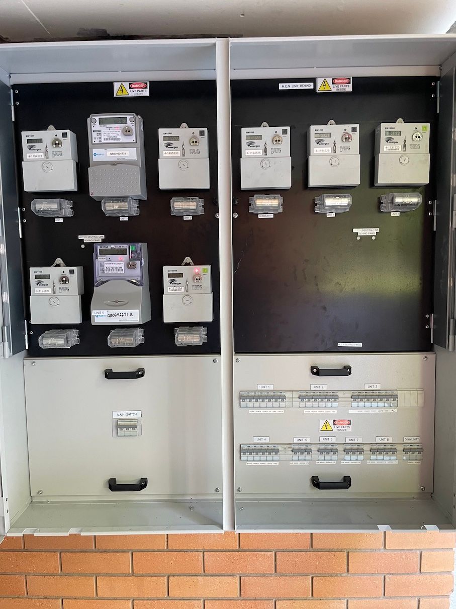 A wall with a bunch of electrical meters on it