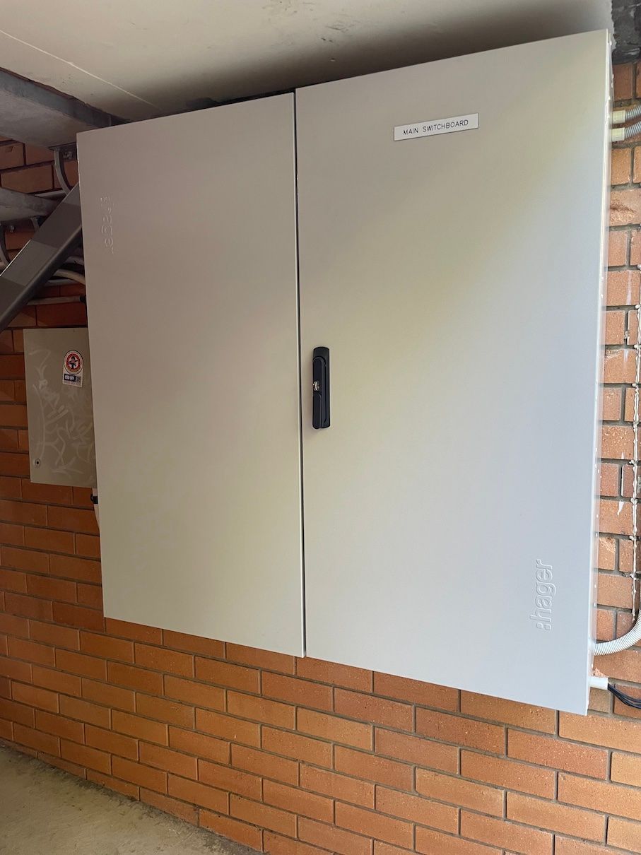 A white cabinet is sitting on a brick wall.