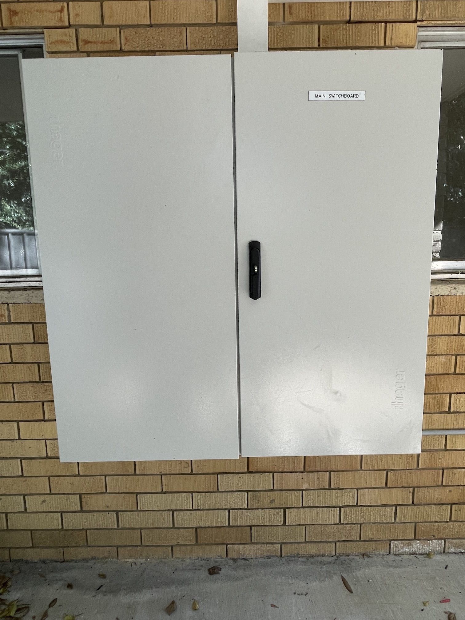 A brick wall with a white cabinet on it