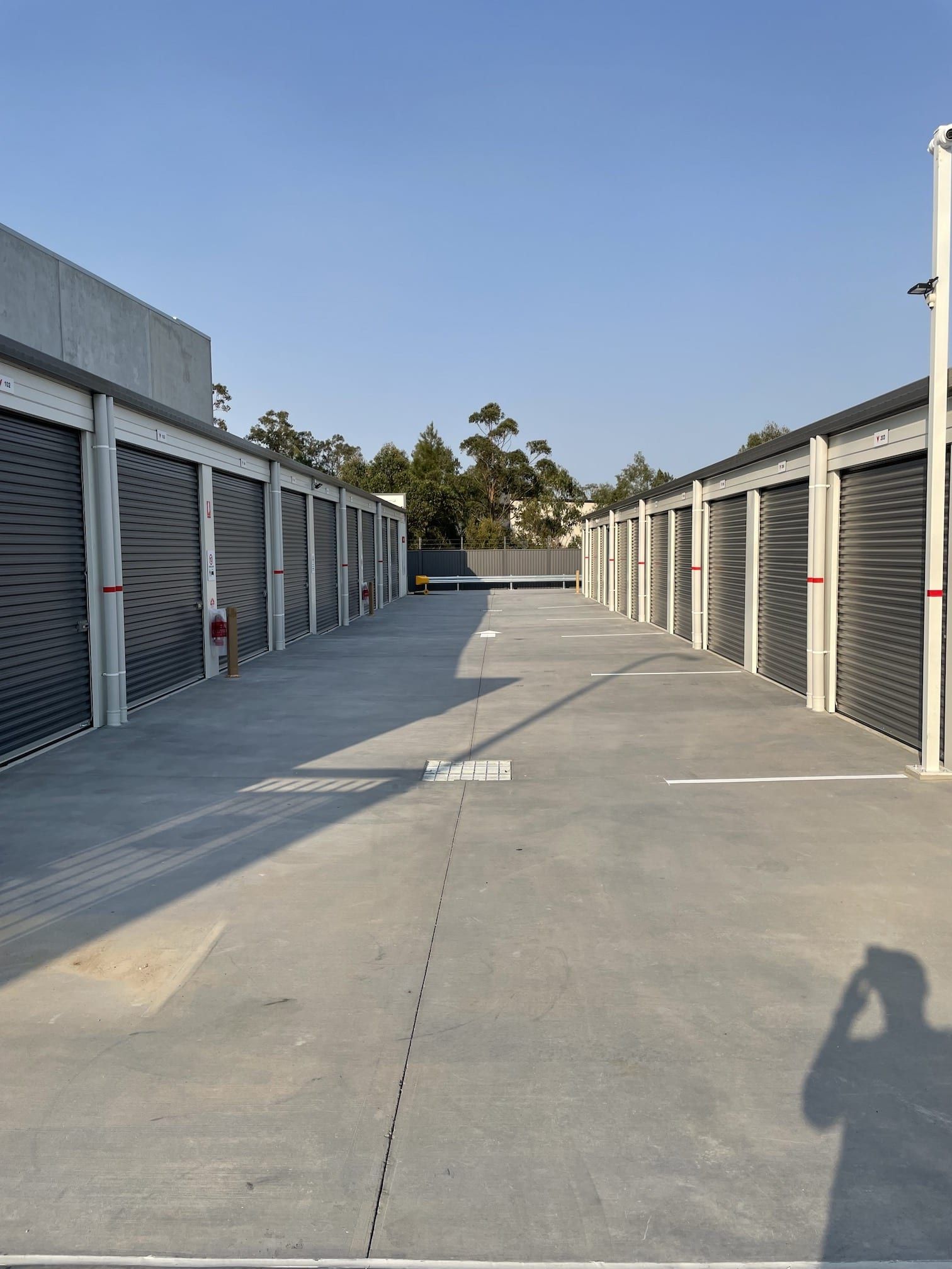 A row of garage doors are lined up in a parking lot.