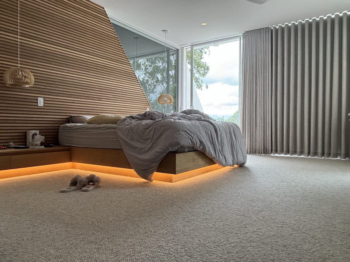 A bedroom with a bed and a dog laying on the floor.