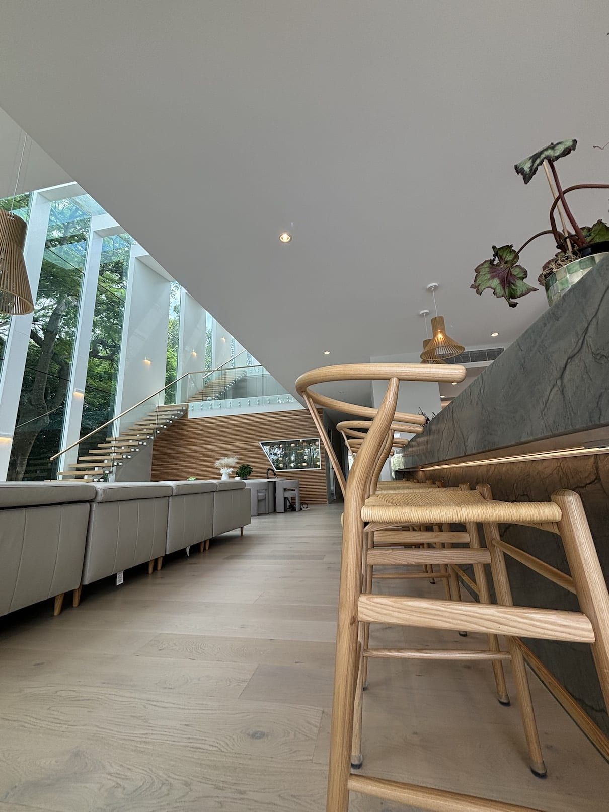 A row of wooden bar stools are sitting next to a counter in a living room.