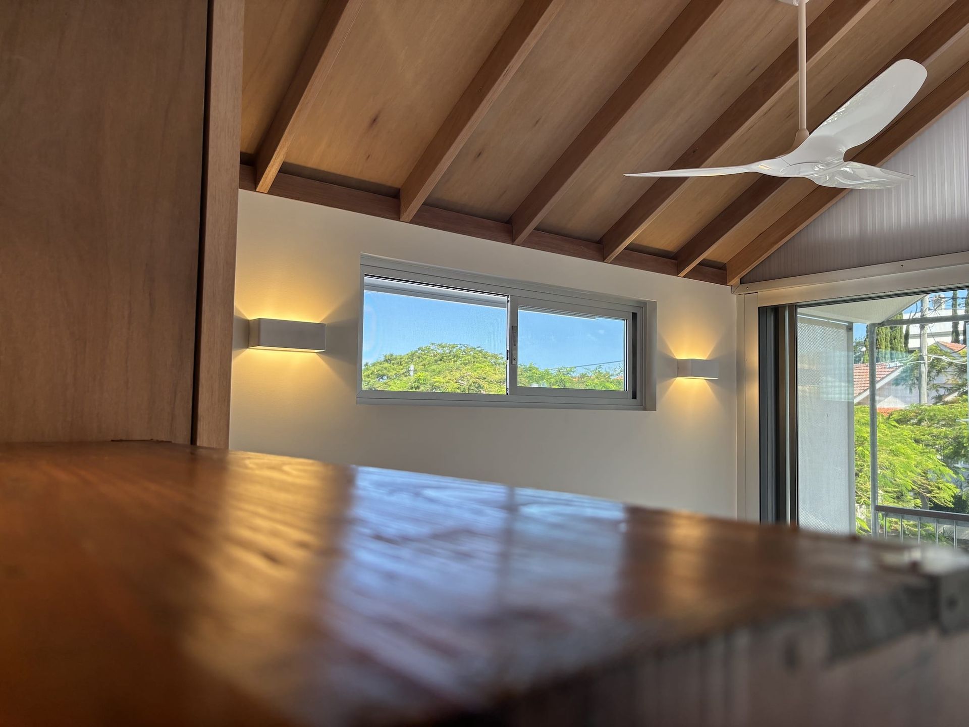 A room with a ceiling fan and a window